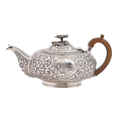 A George IV silver teapot, chased with