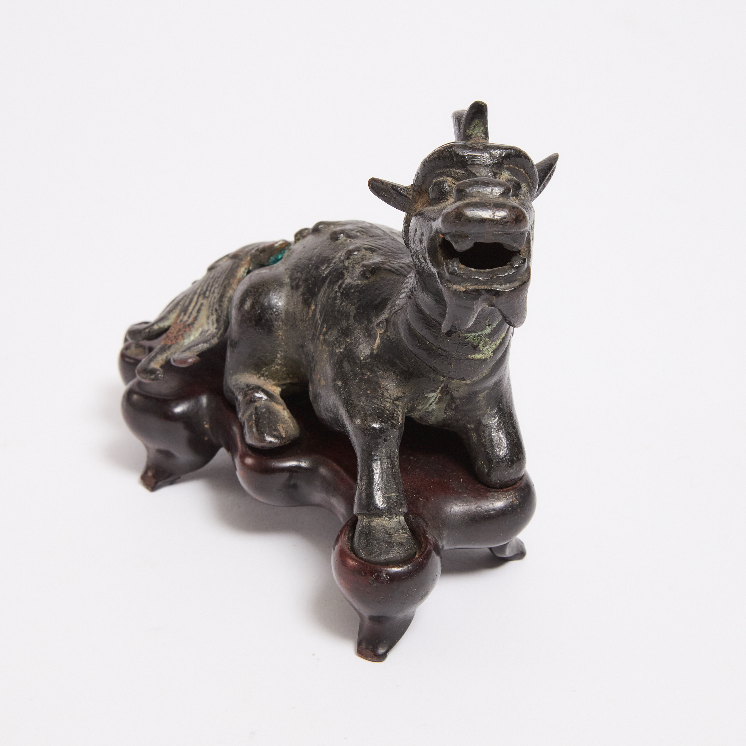 A Small Bronze Figure of a Recumbent