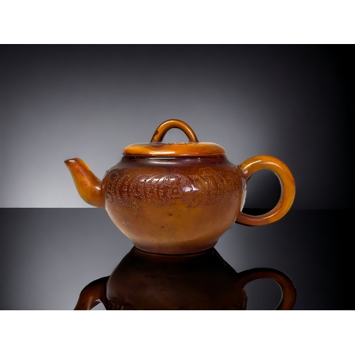 A CHINESE CARVED AMBER TEAPOT.Qing