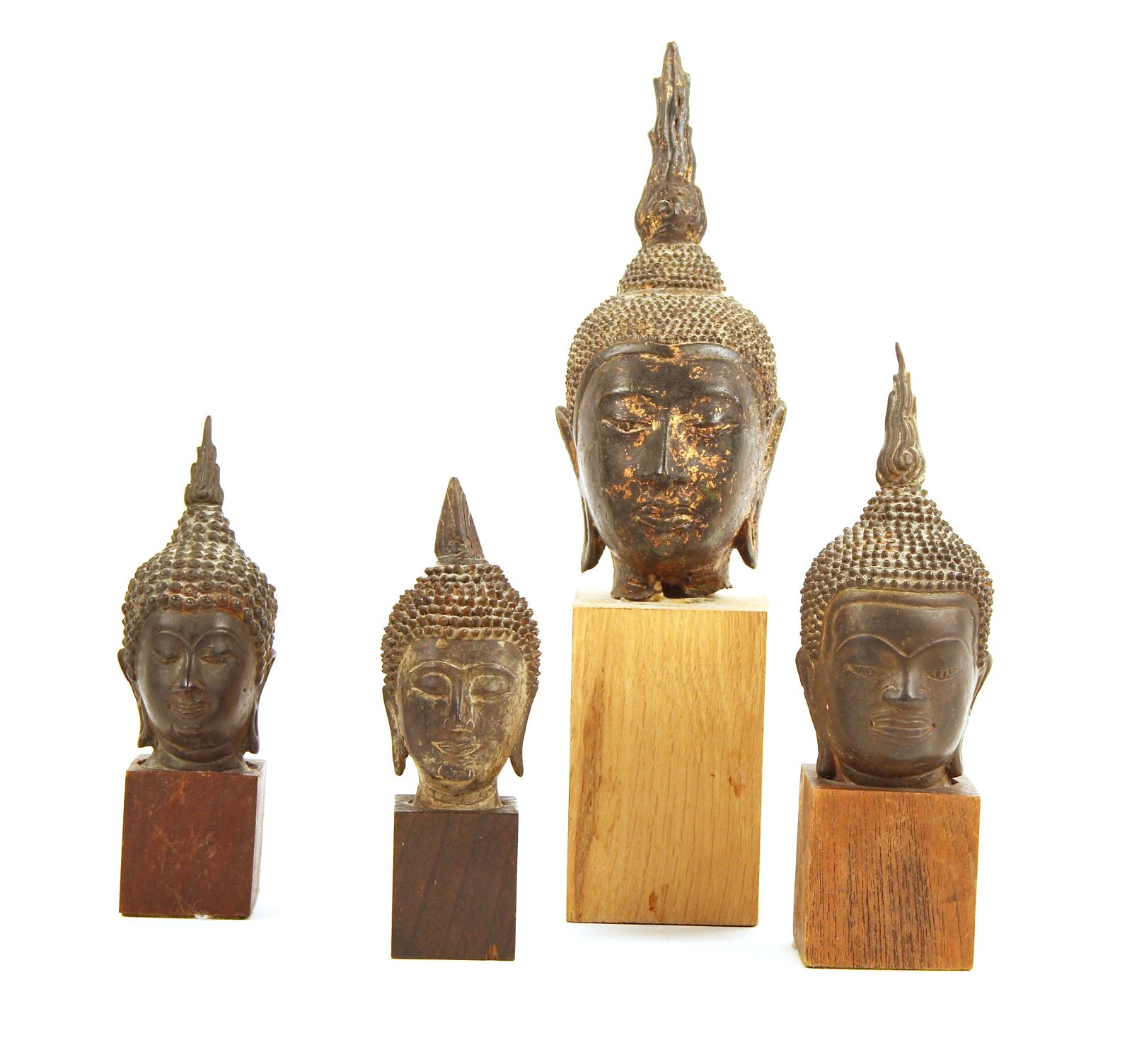 FOUR BRONZE BUDDHA HEADS ON WOODEN