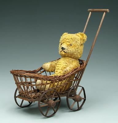 Teddy bear with wicker doll buggy: