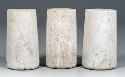 Three white marble pedestals: slightly