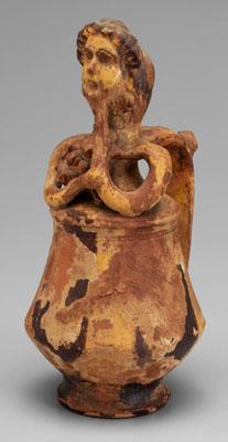 Earthenware mask jug, figure holding