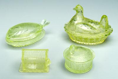 Four lidded vaseline glass dishes: