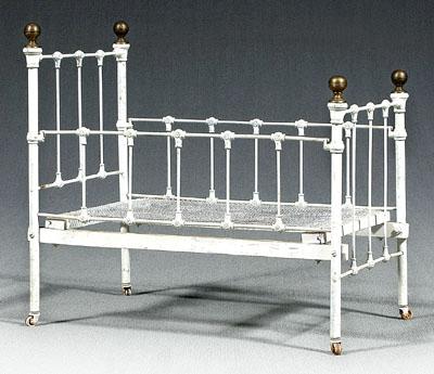 Iron doll bed, brass finials, porcelain