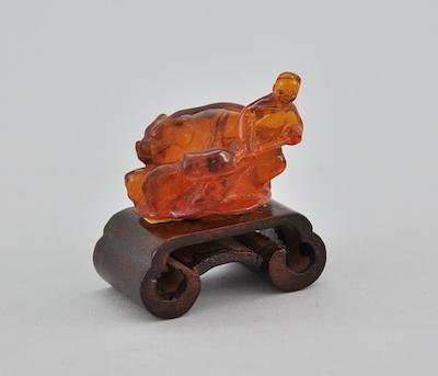 A Carved Amber Miniature Pig Farmer
