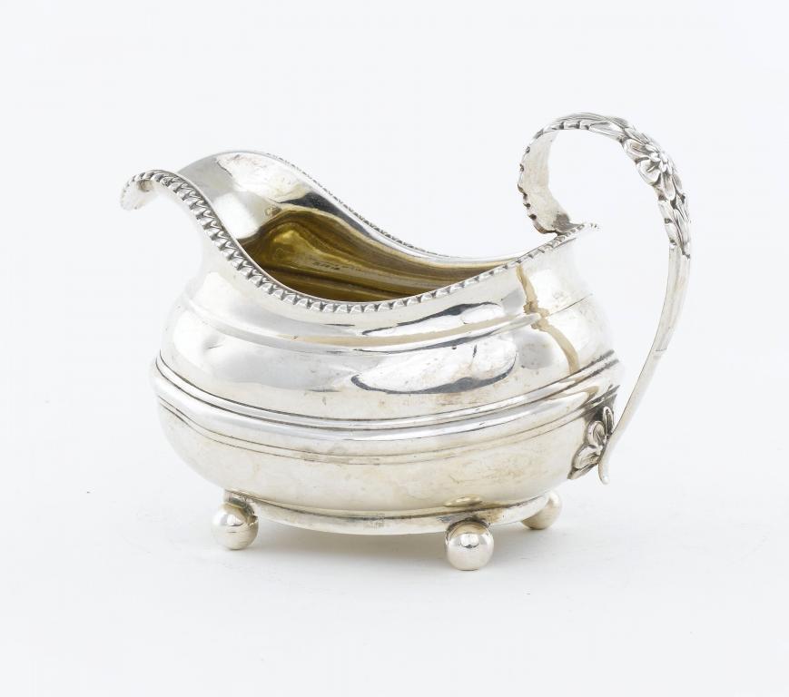 A GEORGE IV CREAM JUG
with gadrooned