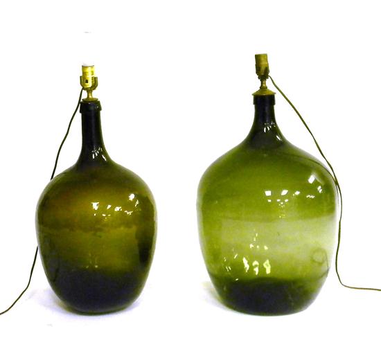 Two bulbous green glass demijohn bottles