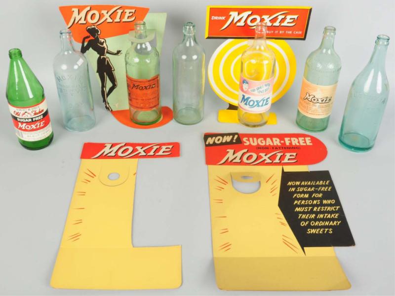 Group of 7 Moxie Bottles & 4 Displays.