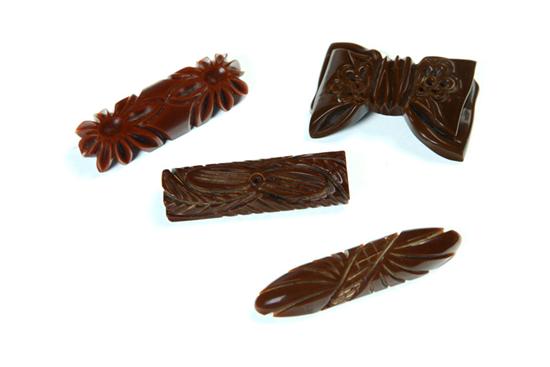 FOUR CARVED EARLY PLASTIC PINS.