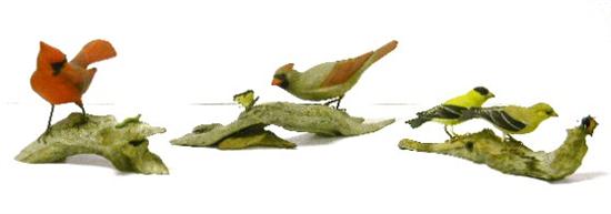 Three wooden bird figurines on 10f25a