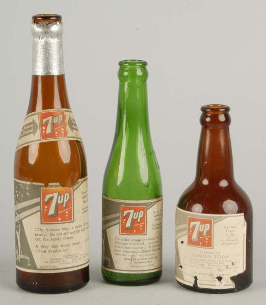 Lot of 3: Assorted 7up Bottles. 
Description