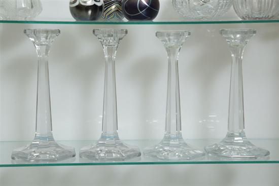 FOUR HEISEY CLEAR GLASS CANDLESTICKS.