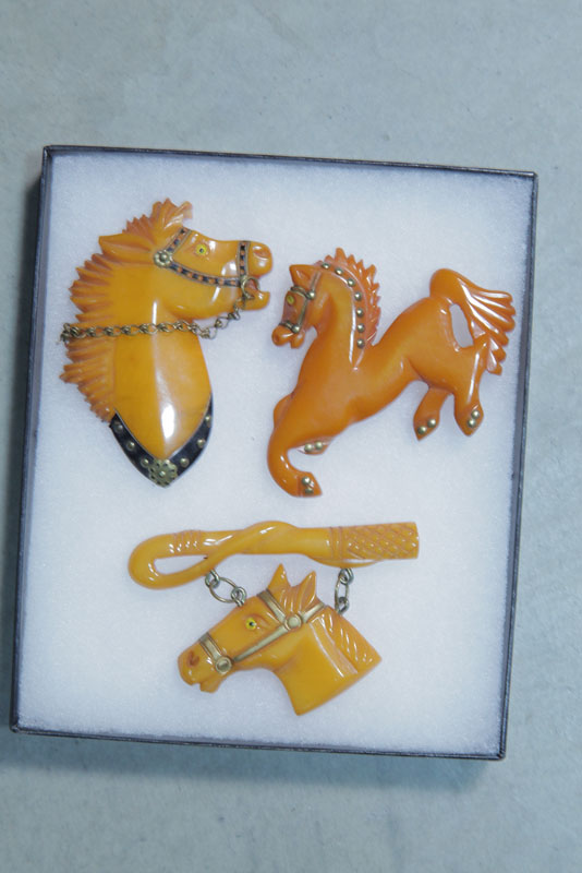 THREE BAKELITE HORSE PINS. All butterscotch