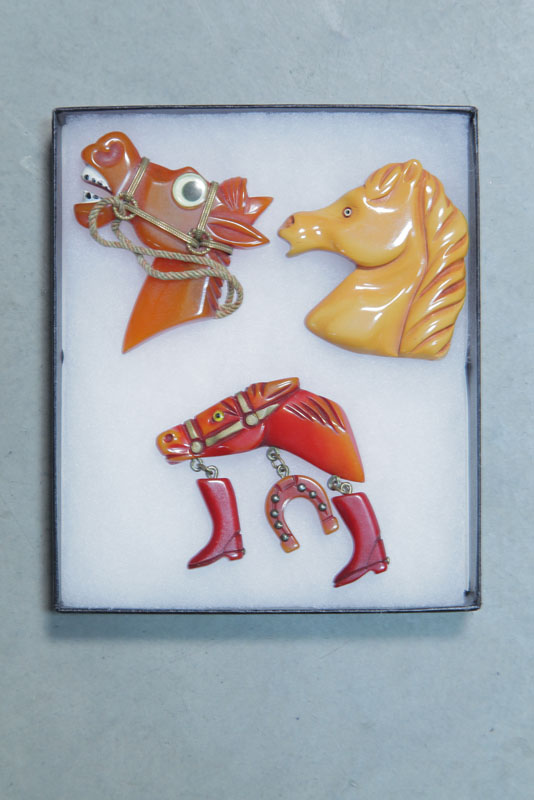 THREE BAKELITE HORSE PINS. One googly-eyed.