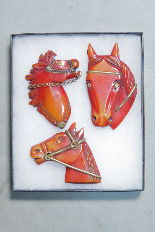 THREE BAKELITE HORSE PINS. All