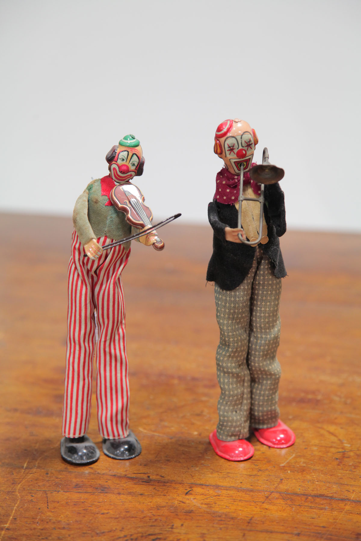 PAIR OF WIND-UP TIN CLOWNS.  Most