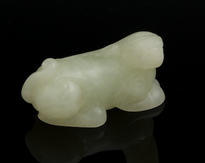 A Carved Jade Lion Pendent Recumbent