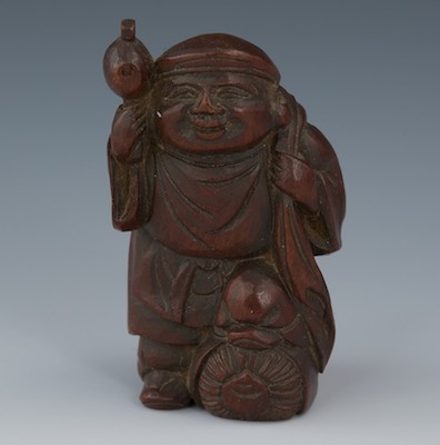 A Carved Wood Netsuke of a Traveler 132896