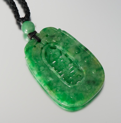 A Carved Green Jade Pendant on