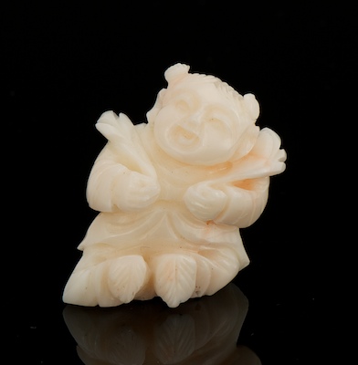 A Carved Angel Skin Coral Figure of
