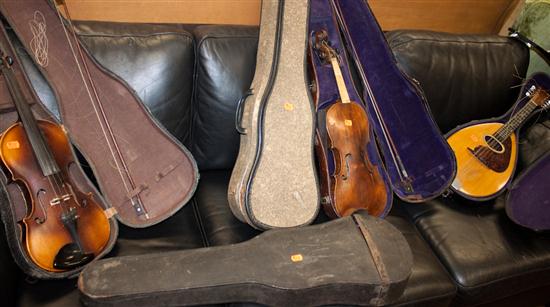 Four student violins with bows in cases;