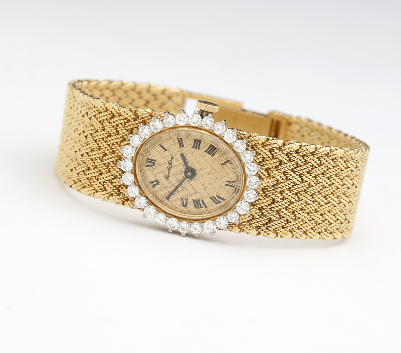 The oval gold tone dial with etched