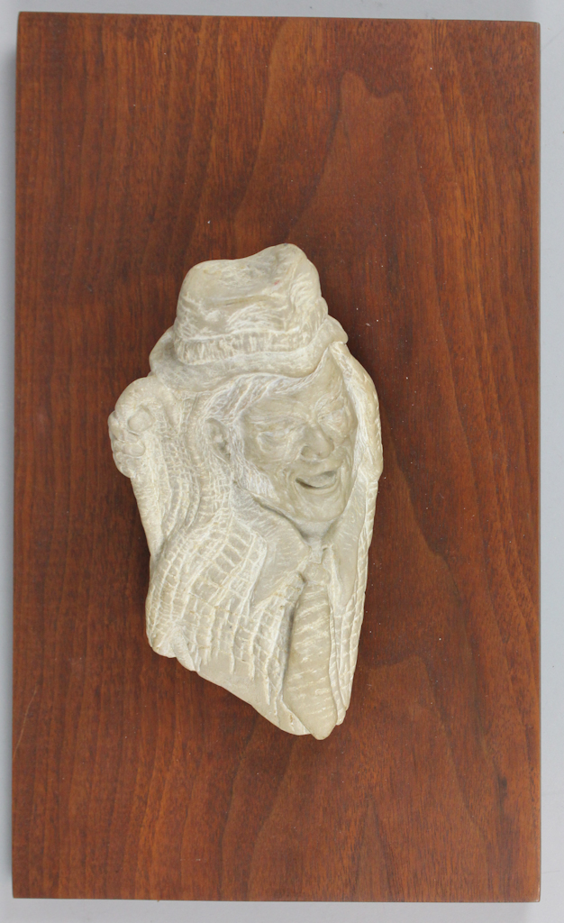 CARVED STONE RELIEF OF A LAUGHING MAN