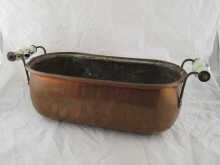 A copper trough with ceramic handles.