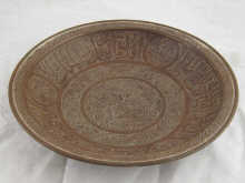 A heavy copper bowl with incised