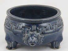 A blue ceramic bowl on three sturdy