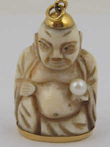 A carved ivory figure a pearl in