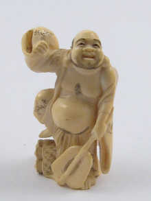 An Oriental ivory carving of a man holding