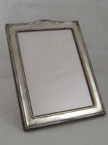 A silver photo frame with cresting 149c31