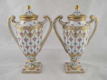 A pair of Dresden covered urns on square