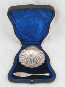 A silver butter shell and knife