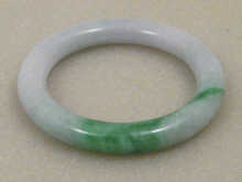 A Chinese green jade bangle 7.5 cm dia.