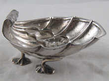 A silver deeply formed shell dish on