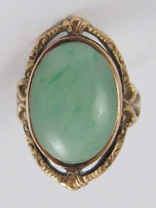 A cabochon jade ring set in yellow