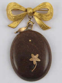 An oval hardstone pendant brooch