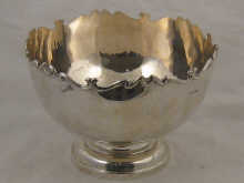 A silver punch bowl with scrolling rim