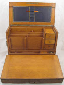 An oak writing cabinet with domed