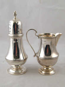 A silver cream jug and caster in