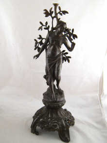 A spelter figure of a woman on an ornate