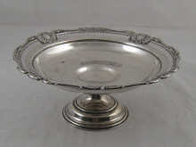 A silver cake dish on stand with pierced