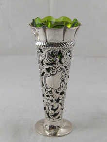 A pierced silver vase with green