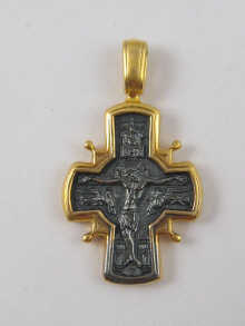 A yellow and white metal crucifix pendant.