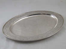 An oval silver dish with reeded rim