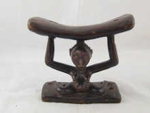 An African neck rest carved as a naked