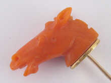 A carved coral stick pin designed